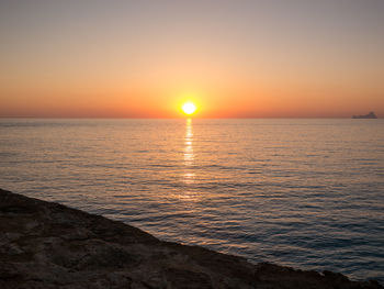 Scenic view of sea against romantic sky at sunset