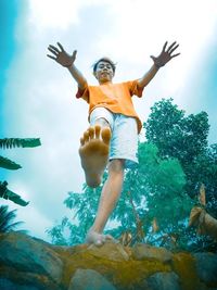 Low angle view of woman with arms raised in water