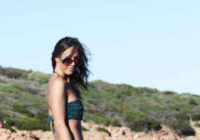 Portrait of smiling young woman standing at beach