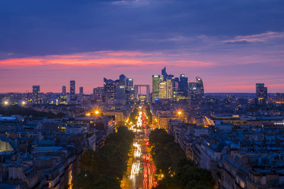 High angle view of city lit up at sunset