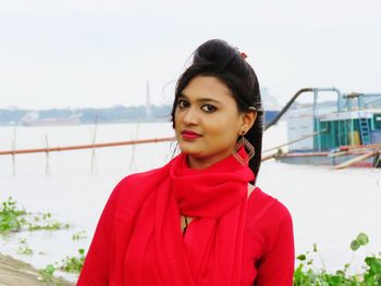 Portrait of woman standing against lake