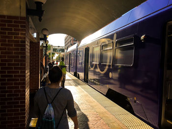 Rear view of woman standing at railroad station