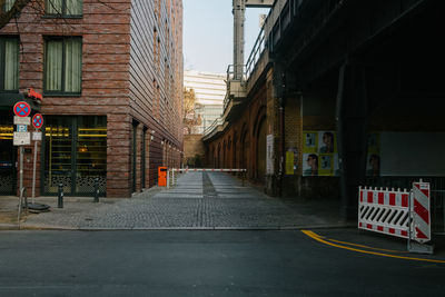 Empty road amidst buildings in city