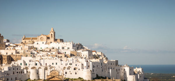 Buildings in town against clear sky