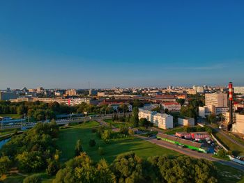 High angle view of buildings in city against clear blue sky