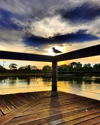 Pier on lake at sunset