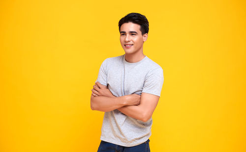 Portrait of a smiling young man against yellow background