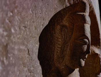 Close-up of buddha statue against wall