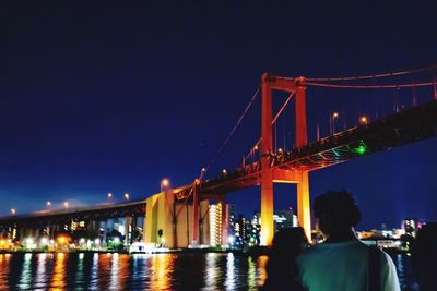 Rear view of bridge over river at night