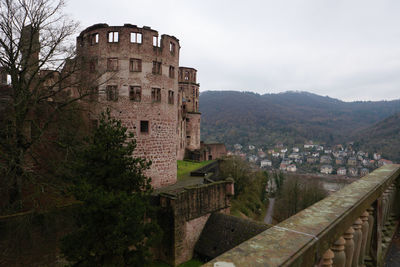 Heidelberg castle looking up under cloudy skies.