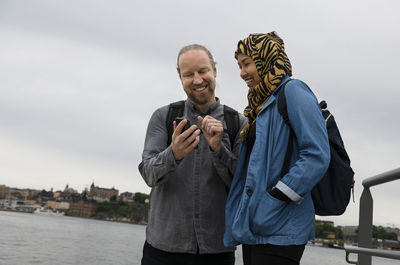 Smiling man and woman looking at cell phone