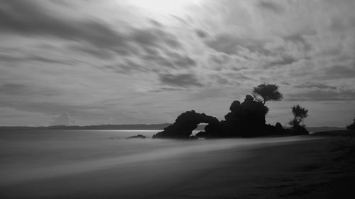 Silhouette people on beach against sky