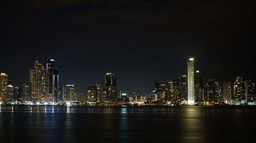 Illuminated buildings against sky at night