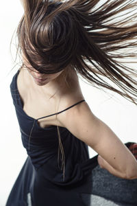 Young woman dancing with flying hair in a black flying dress