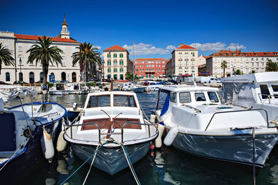 Boats moored in canal by buildings in city