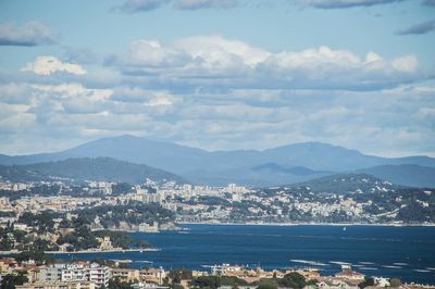 Aerial view of townscape by sea against sky