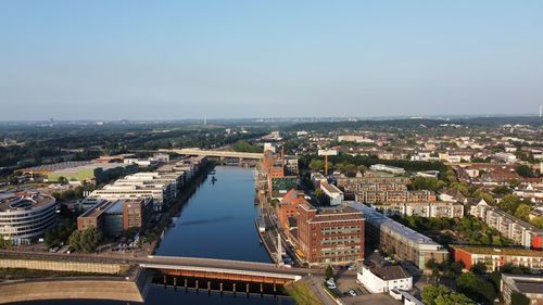 High angle view of river amidst buildings in city against sky