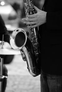 Midsection of man playing trumpet while standing outdoors