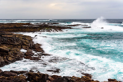 Scenic view of sea with rocky beach against sky. fuerteventura, canary islands, spain