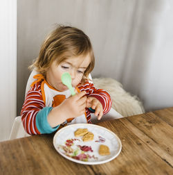 Cute girl eating food at home