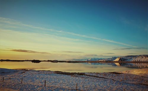 Scenic view of lake against sky during winter