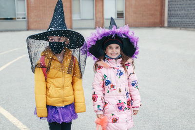 Full length of girls wearing costume standing in front of building