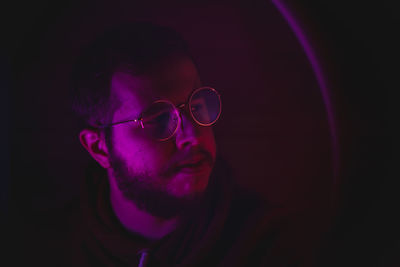 Close-up portrait of young man against black background