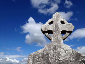 Low angle view of celtic cross against sky