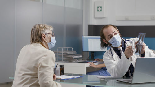 Doctor discussing over x-ray with patient in hospital