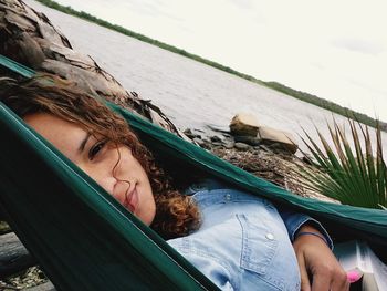 Close-up of young woman on beach against sky