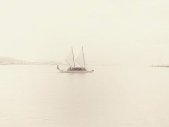 Sailboat sailing on sea against sky