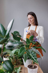 Portrait of young woman holding potted plant