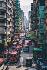 Traffic on city street by buildings against sky