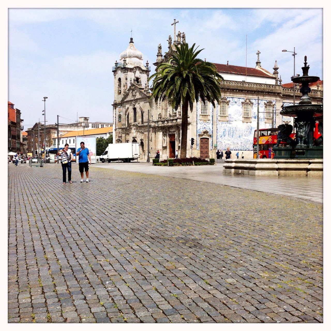 building exterior, architecture, built structure, transfer print, street, sky, auto post production filter, cobblestone, incidental people, city, road, sidewalk, men, transportation, outdoors, day, person, sunlight