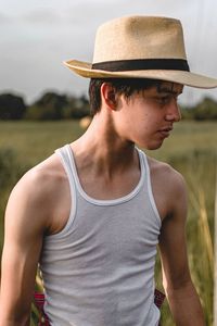 Young man wearing hat standing on land