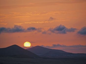 Scenic view of silhouette mountains against sky during sunset