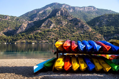 Multi colored boats by sea against mountains 