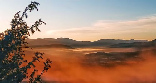 Scenic view of silhouette mountains against sky during sunset