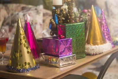 Close-up of colorful gift boxes and party hats on table during christmas