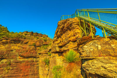 Low angle view of rock formation against clear blue sky