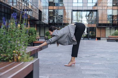 Businesswoman practicing stretching exercise at office park