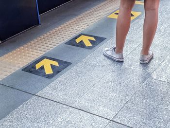Low section of woman standing on tiled floor