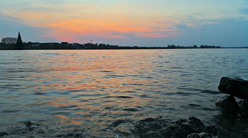 Reflection of clouds in sea at sunset