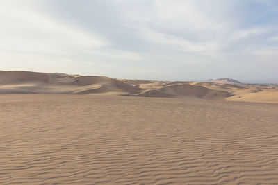 Rippled sand in desert against sky