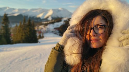 Close-up portrait of young woman in warm clothing outdoors