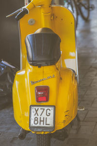 Close-up of yellow car on street