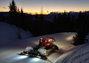 Scenic view of snow covered field against sky during sunset