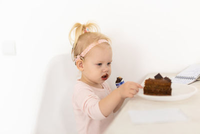 Portrait of cute girl eating food at home