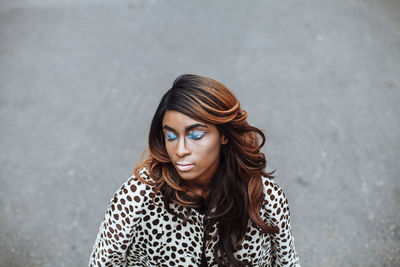 Portrait of young female model posing on road in city