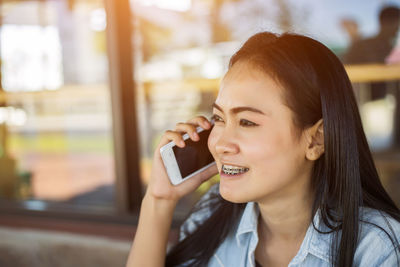 Portrait of smiling young woman using mobile phone